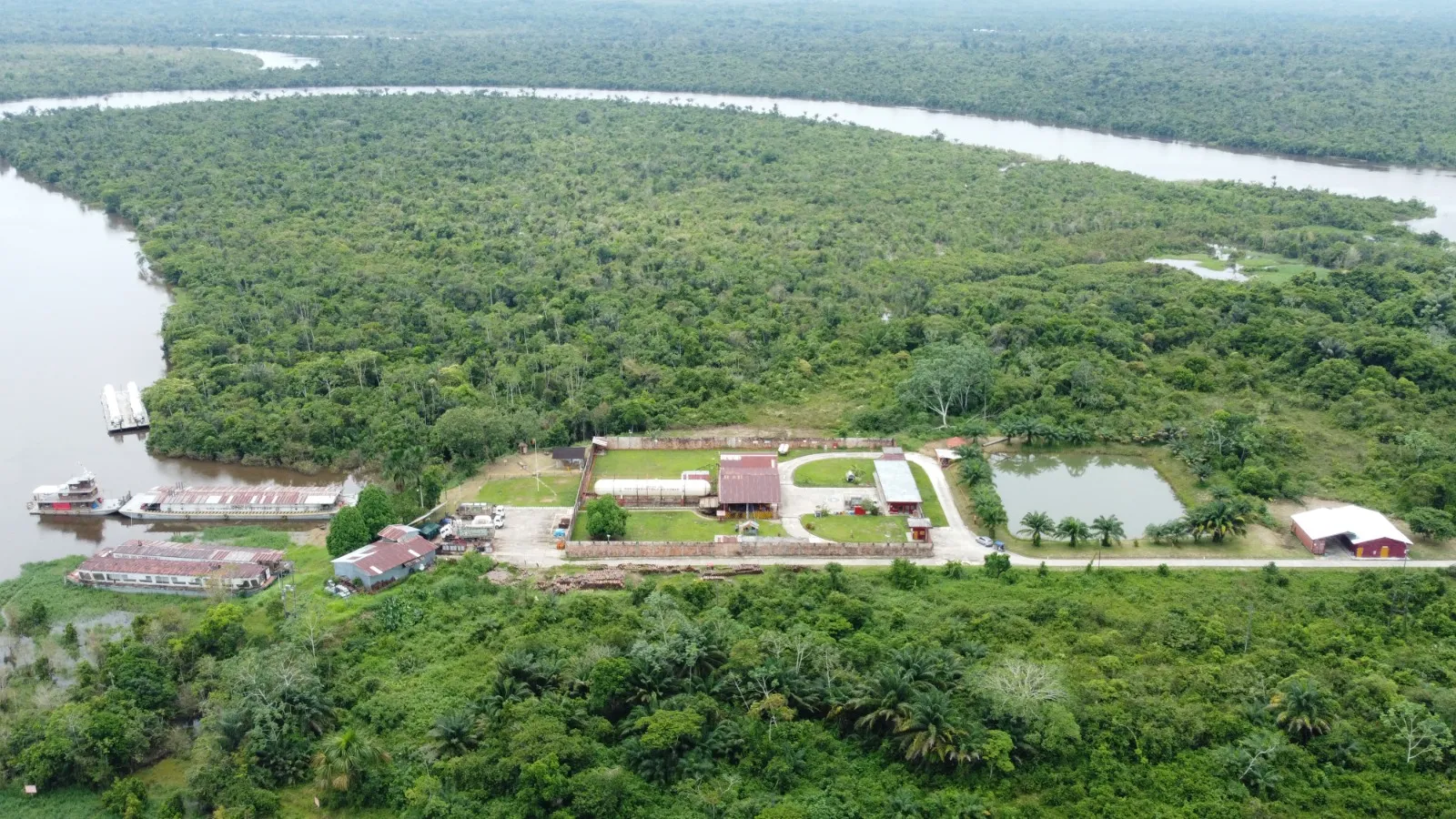 Vista aérea amplia de la planta rodeada de selva, con el río formando un meandro